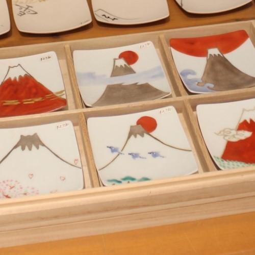 色絵銀彩富士図9cm角小皿シリーズ<br />福珠窯では丁寧に細工された白磁の素地に色絵と銀彩で様々な富士図を表現しています。<br />日の出富士、桜富士、千鳥富士、赤富士、雲上富士など、様々な富士の景色をお楽しみいただけます。